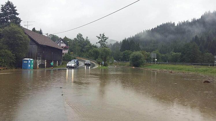 Die Wilde Rodach hat am Sonntag in Schnappenhammer einen Teil der Straße überflutet. Fotos: Claudia Wittmann