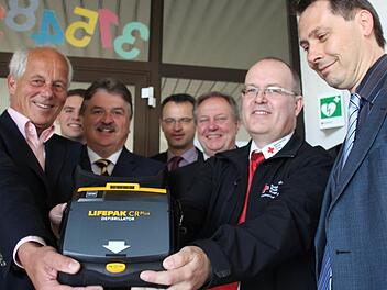 Einer von vier neuen Defibrillatoren. Unser Bild zeigt (von links) Schulleiter Michael Pfitzner, Jens Hammerschmidt von der Kulmbacher Bank, Landrat Klaus Peter Söllner, BRK-Kreisgeschäftsführer Jürgen Dippold, den Untersteinacher Bürgermeister Volker Schmiechen, BRK-Rettungsdienstleiter Michael Martin und den Stadtsteinacher Bürgermeister Roland Wolfrum. Foto: Matthias Beetz