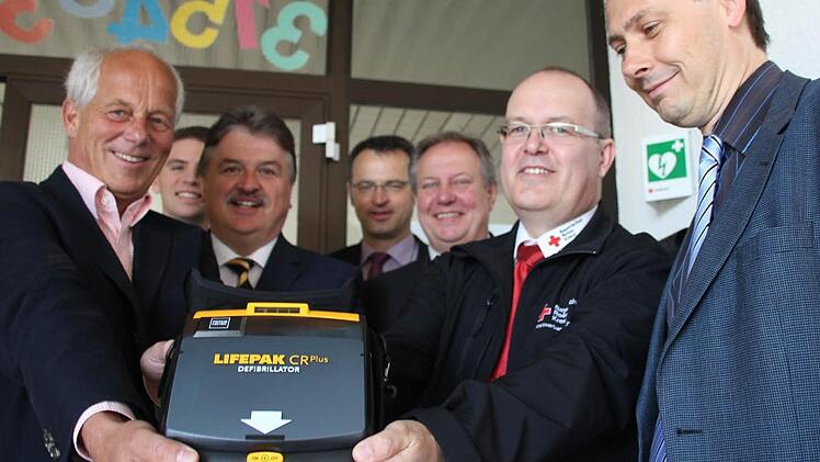 Einer von vier neuen Defibrillatoren. Unser Bild zeigt (von links) Schulleiter Michael Pfitzner, Jens Hammerschmidt von der Kulmbacher Bank, Landrat Klaus Peter Söllner, BRK-Kreisgeschäftsführer Jürgen Dippold, den Untersteinacher Bürgermeister Volker Schmiechen, BRK-Rettungsdienstleiter Michael Martin und den Stadtsteinacher Bürgermeister Roland Wolfrum. Foto: Matthias Beetz
