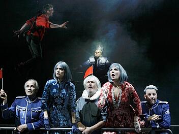 Während Orlando (Julian Keck) schwebend zum Kampf ansetzt, verharren (v. l.) Le Beau (Jochen Kuhl), Celia (Lilly Gropper), Touchstone (Frank Damerius), hinten der neue Herzog (Pius Maria Cüppers), Rosalinde (Josephine Köhler), Oliver (Marco Steeger) bass erstaunt.  Foto: Marion Bührle