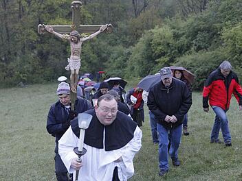 Robert Haßfurther geht dem Kreuz nur ausnahmsweise voran, denn die steile Wiese zum Rothof ist eine Herausforderung für die Bittgänger in Bamberg. Fotos: Sebastian Martin