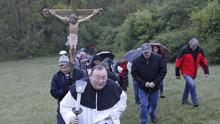 Robert Haßfurther geht dem Kreuz nur ausnahmsweise voran, denn die steile Wiese zum Rothof ist eine Herausforderung für die Bittgänger in Bamberg. Fotos: Sebastian Martin