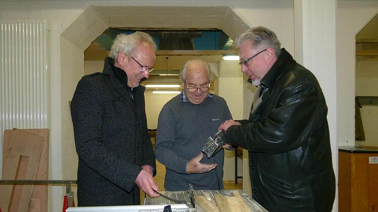 Vor der offiziellen Eröffnung besuchte Dekan Hans-Martin Lechner (links) mit Initiator Bernd Bauer-Banzhaf (rechts) den "Männerschuppen", in dem Elektromeister Otto Schmitt schon werkelt. Foto: Marion Krüger-Hundrup