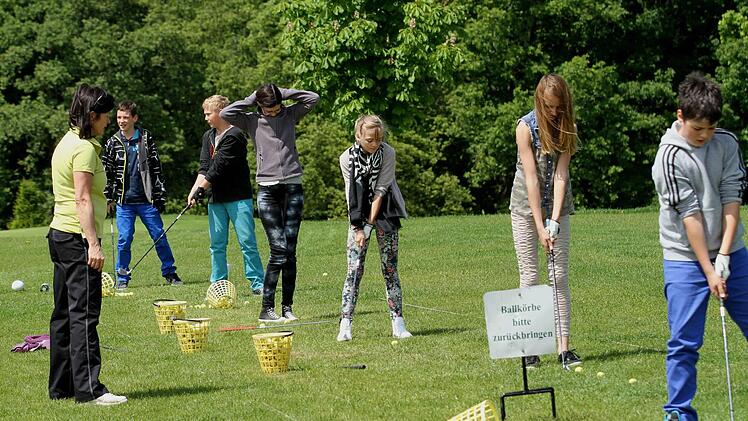 Die Schüler trainieren den Abschlag auf der Driving-Ranch.
