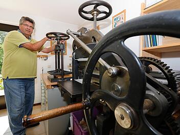 Hermann Ehreiser legt das fertige Buch in die Presse. Im Vordergrund die "alte Krause" zum Beschnitt der Buchkanten.  Foto: Matthias Hoch
