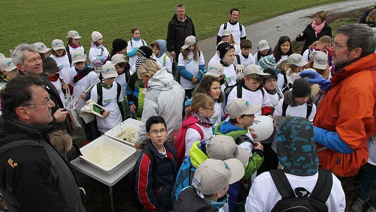 Biologe Volker Kirschenlohr (rechts) erklärt den Kindern die Vorgehensweise einer Bachuntersuchung. Mit auf dem Bild ZWE- Geschäftsführer Richard Hubert (links) und Ver-bandsvorsitzender Johann Kalb (2. v. l.).