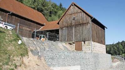 Noch eine Reihe Gabionen soll auf die bestehende Mauer aufgesetzt werden, dann ist die Stütze für die uralte Scheune fertig.