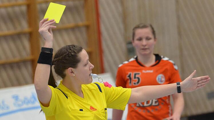 Auch beim Handball gibt es gelbe Karten: Hier kassiert eine Spielerin des HC Erlangen die Verwarnung von Lisa Wenzke. Fotos: Jürgen Schmitt
