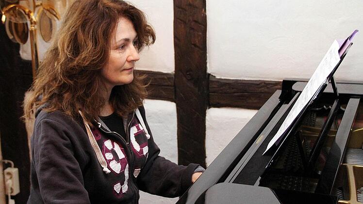 Barbara Moritz an ihrem Flügel im Wohnzimmer. Hier  hat sie die beiden Weihnachtslieder komponiert, die bei einem Konzert am 8. Dezember erstmals in Münnerstadt aufgeführt werden.  Foto: Thomas Malz
