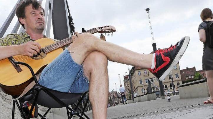 Nun sitzt Moritz Rabe auf der anderen Seite der Kettenbrücke und musiziert weiter. Foto: Matthias Hoch