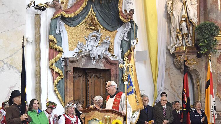 Im Chorraum saßen die Landsmannschaften mit ihren traditionellen Trachten und Fahnen. Pater Heribert Arens hielt die Predigt. Foto: Andreas Welz