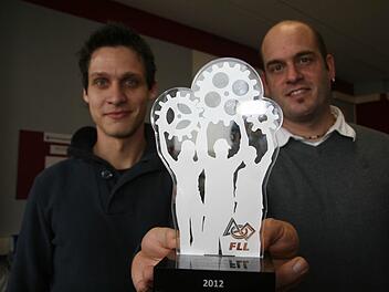 "Wir haben nichts gemacht", sagen die beiden Lehrer Alexander Heinlein und Martin Jungkunz, zeigen aber dennoch den Pokal, den die RobolutionS eingeheimst haben