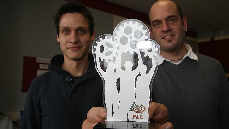 "Wir haben nichts gemacht", sagen die beiden Lehrer Alexander Heinlein und Martin Jungkunz, zeigen aber dennoch den Pokal, den die RobolutionS eingeheimst haben