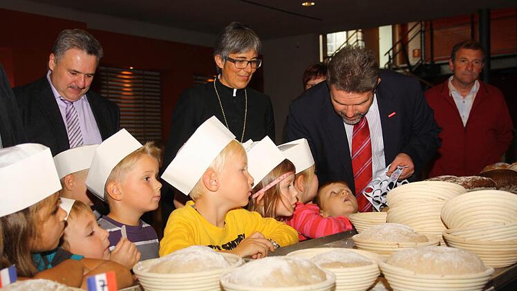 Regionalbischöfin Dorothea Greiner und der Präsident der Handwerkskammer, Thomas Zimmer, unterstützen Kulmbacher Kinder beim Backen des "Gott-sei-Dank-Brotes".  Foto: Geyer
