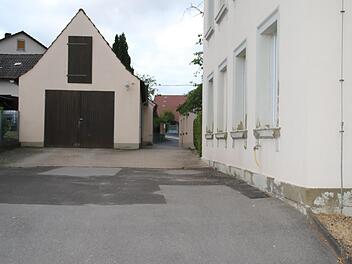Platz und Durchgang an der Alten Schule in Aura sollen saniert werden, beschloss der Gemeinderat beim Vor-Ort-Termin.