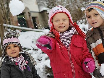 Lilli, Sarah und Raphael (von links) haben im Rosenbergkindergarten viel Spaß am Schnee.  Fotos: Jan Koch