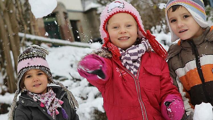 Lilli, Sarah und Raphael (von links) haben im Rosenbergkindergarten viel Spaß am Schnee.  Fotos: Jan Koch