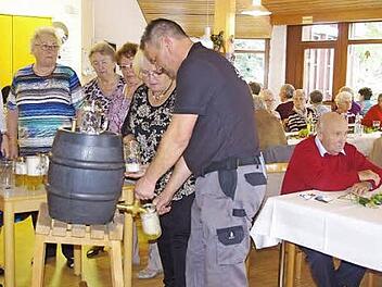 Hausmeister Tobias Heller und die t&uuml;chtigen Helferinnen der BRK-Senioren lie&szlig;en sofort das frisch gezapfte Bier in die bereitgehaltenen Ma&szlig;kr&uuml;ge flie&szlig;en. Foto: Heike Sch&uuml;lein