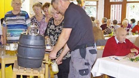 Hausmeister Tobias Heller und die t&uuml;chtigen Helferinnen der BRK-Senioren lie&szlig;en sofort das frisch gezapfte Bier in die bereitgehaltenen Ma&szlig;kr&uuml;ge flie&szlig;en. Foto: Heike Sch&uuml;lein