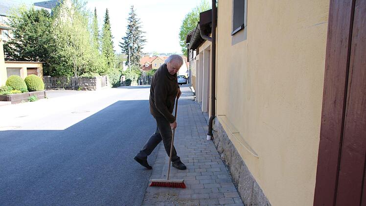 Otto Hußlein fegt wieder einmal seinen Gehweg. Die würden überhaupt nicht gereinigt, sagt er. Thomas Malz