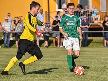 Der blutige Sander André Lörzer im Duell mit dem Kitzinger Towart Florian Nöth Foto: Ryan Evans