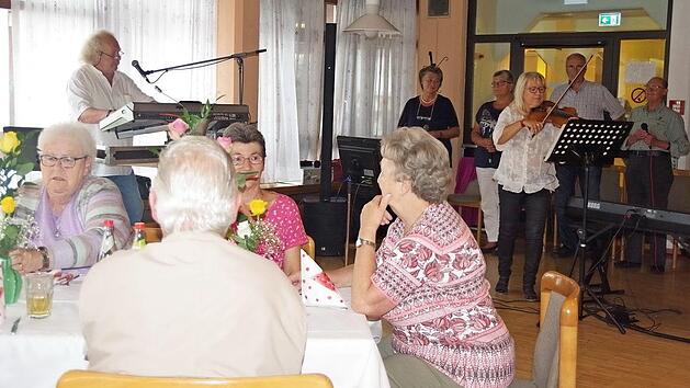 Die S&auml;nger der BRK-Seniorenband pr&auml;sentierten unter Leitung von Rainer Lohr (links) einen bunt gemischten musikalischen Blumenstrau&szlig;. An der Geige sowie am Piano bezauberte einmal mehr Margitta Bergfeld. Foto: Heike Sch&uuml;lein