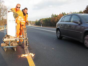 Mitarbeiter der Fürther Spezialfirma Schötz entfernen die gelben Baustellenmarkierungen von der neuen Fahrbahn.  Fotos: Andreas Dorsch
