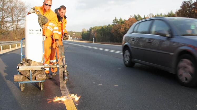 Mitarbeiter der Fürther Spezialfirma Schötz entfernen die gelben Baustellenmarkierungen von der neuen Fahrbahn.  Fotos: Andreas Dorsch