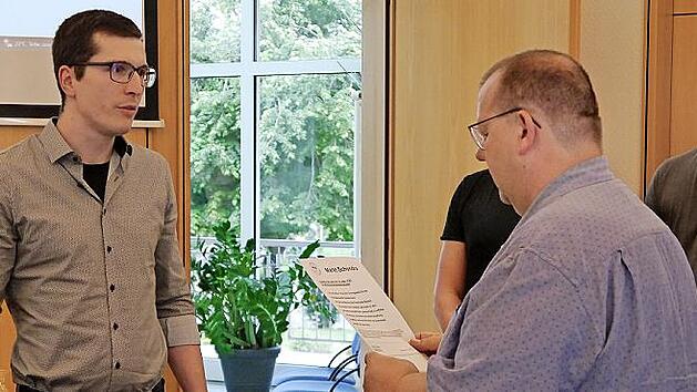 Bürgermeister Bernold Martin(rechts) vereidigt Tobias Fritzmann (ABS) aus Schildeck als neuen Marktgemeinderat.