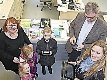 Mit Tablets, E-Reader, Smartphone und PC können künftig Nutzer über das "KOMM" in Untermerzbach Medien herunterladen und darin schmökern. Beim "Startschuss" am Freitagnachmittag nahmen schon mal (von rechts) Christine Lieb, Bürgermeister Helmut Dietz und die Kids, Jule, Mia und Jana diese "Spielzeuge" in die Hand. KOMM-Leiterin Ute Morgenroth (links) freut sich auf viele Leser. Foto: Helmut Will