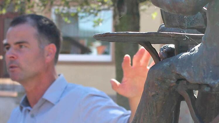 Am Dorfbrunnen: Michael Bauer erläutert wie der Bronzeguss hergestellt wurde.
