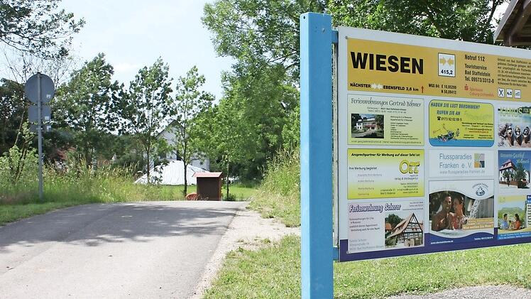 Hinter diesem Schild und der Sitzgruppe nahe der Kanuanlegestelle Wiesen wurde der Platz mit Feuerstelle von Jugendlichen angelegt.