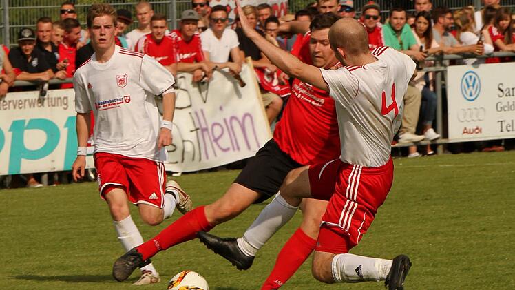 Auch in der Abwehr zeigten die Trossenfurter ihre Stärke. Hier grätscht Manuel Herbst (rechts) fair in den Ball und verhindert den Durchbruch des Gädheimer Stürmers. Links der Trossenfurter Matthias Hoh