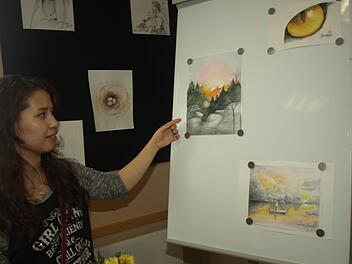 Einen Einblick das künstlerische Schaffen der 18-jährigen Afghanin Golnessa Youseffi vermittelt eine Ausstellung in der evangelischen Friedenskirche. Auf unserem Foto ist die junge Malerin vor einer Tafel.  Foto: Stefan Geiger