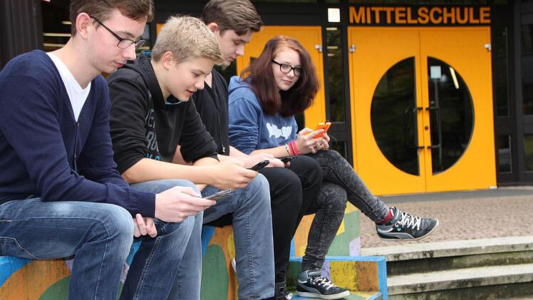 Online auf dem Schulhof: Sascha (von links), Lorenz, Nick und Celina haben ihre Smartphones immer dabei. Foto: Ulrike Müller