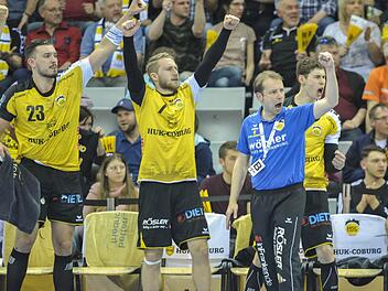 Solche Bilder wollen die Handballfans in der HUK-Arena sehen. Während sich Co-Trainer Ralph Baucke (rechts) beim Erstellen seiner Statistik nicht aus der Ruhe bringen lässt, jubeln (von links): Patrick Weber, Marcel Timm, Lukas Wucherpfennig, Cheftrainer Jan Gorr und Max Jaeger. Am Sonntag um 17 Uhr steigt das fränkische Derby gegen die DJK Rimparer Wölfe im Coburger "Sporttempel". Foto: Hagen Lehmann