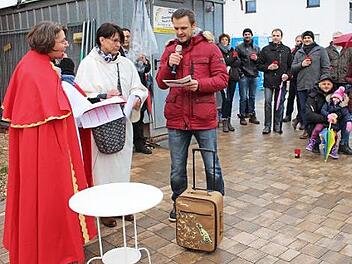 Ein Neubürger mit Koffer kommt an; im Bild links Pfarrerin Angelika Steinbauer als Petrus. Foto: Evi Seeger
