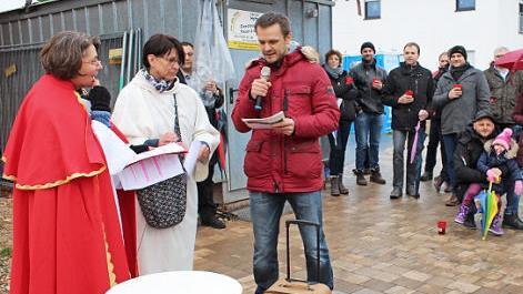 Ein Neubürger mit Koffer kommt an; im Bild links Pfarrerin Angelika Steinbauer als Petrus. Foto: Evi Seeger