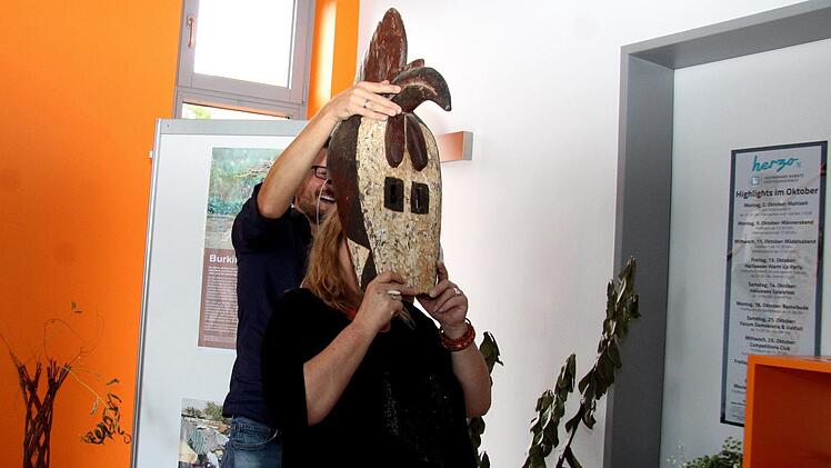 Thomas Lang setzt Karin Peuker-Göbel vom Partnerschaftsverein die Tanzmaske Bobo auf.  Foto: Richard Sänger