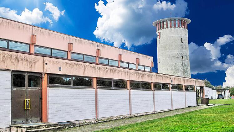 Die Mehrzweckhalle im Vordergrund wird mit großer Sicherheit im kommenden  Jahr nun doch nicht saniert, da der Gemeinde die Mittel fehlen. Was aus dem  Wasserturm im Hintergrund wird, bleibt nach der jüngsten Sitzung des  Gemeinderates noch unklar. Foto: Dieter Britz