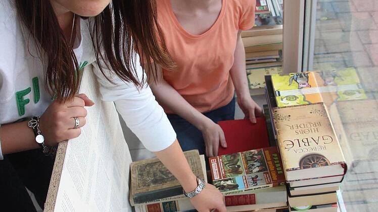 Alexandra Pohl und Maren Fiedler mauern Wände und Häuser aus Büchern. Foto: Mariell Dörrschmidt