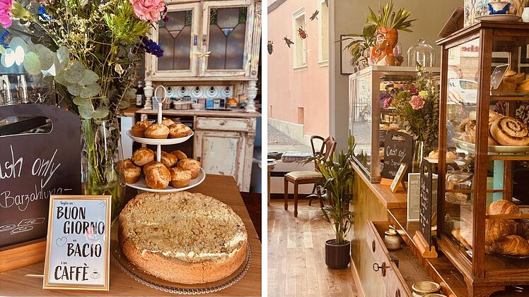 Gem&uuml;tliches Caf&eacute; mit vintage Dekor. Auf einem Holztisch stehen ein Kuchen, Muffins, Blumen und ein Schild mit italienischer Begr&uuml;&szlig;ung. Die Vitrine zeigt Geb&auml;ck, das Ambiente wirkt einladend.