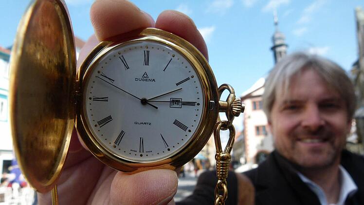 Michael Wieden zeigt auf dem Marktplatz eine Uhr als Symbol für die innere Uhr, der die Chrono-Biologen ihre ganze Aufmerksamkeit widmen. Foto: Anja Vorndran