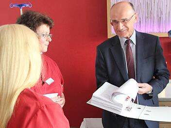 Die beiden Hebammen Annette Storkan und Birgitta Wohner-Finger (von links) übergaben die 21 828 Unterschriften an Landrat Wilhelm Schneider. Das sind immerhin zwei volle Ordner.  Foto: Klaus Schmitt