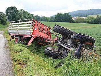 Auf der Seite blieb der Traktor neben dem Feldweg liegen. Der Ladewagen stürzte nicht um. Der Fahrer blieb unverletzt.  Foto: Helmut Will