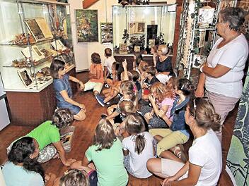Die Ausstellung "Zauberschloss und Märchenwald" auf Schloss Aschach besuchten die Kinder der Sommerferien-Kinderbetreuung der Arbeiterwohlfahrt und des Generationennetzes Bad Kissingen. Museumspädagogin Katja Kraus (links im Hintergrund) las ihnen das Märchen "Rotkäppchen" vor. Rechts im Hintergrund Christine Müller und Rosalinde Heider.  Foto: Dieter Britz