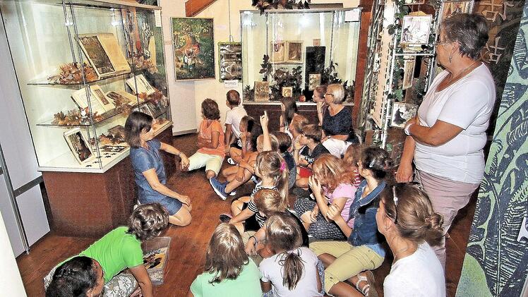 Die Ausstellung "Zauberschloss und Märchenwald" auf Schloss Aschach besuchten die Kinder der Sommerferien-Kinderbetreuung der Arbeiterwohlfahrt und des Generationennetzes Bad Kissingen. Museumspädagogin Katja Kraus (links im Hintergrund) las ihnen das Märchen "Rotkäppchen" vor. Rechts im Hintergrund Christine Müller und Rosalinde Heider.  Foto: Dieter Britz