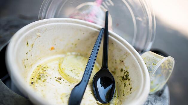 Gebrauchtes Plastikgeschirr liegt auf einem M&uuml;lleimer.   In T&uuml;bingen soll es bald eine Steuer auf Einwegverpackungen geben.