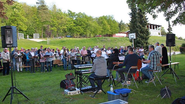 Beim Freibadgottesdienst ist vor allem auch die Kulisse, mitten in der Natur mit Blick auf Ebern, ein Element das den Glauben besonders erlebbar macht, oder in der Bildhaftigkeit der Farben, das Blau, das Umfangen Gottes, sichtbar macht, da der Blick in den blauen Himmel unverstellt ist.