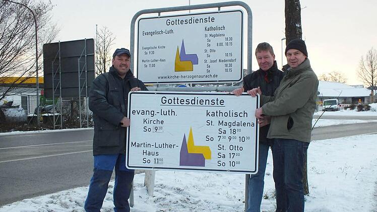 Kirchenrat Walter Drebinger, Pfarrgemeinderat Manfred Welker und Kirchenrat Thomas Kotzer (v. l.) zeigen vor dem neuen Schild das alte Exemplar. Foto: privat.